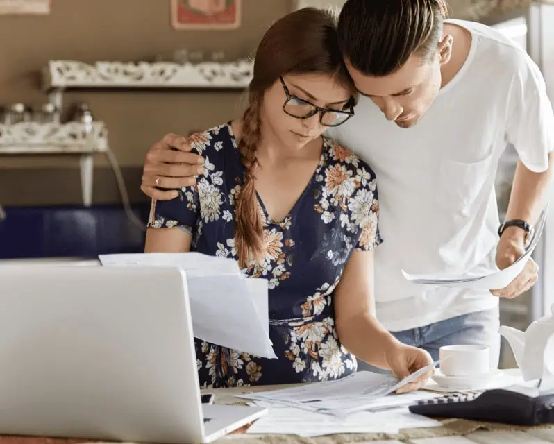 Couple looking at home loan statement and thinking about refinance